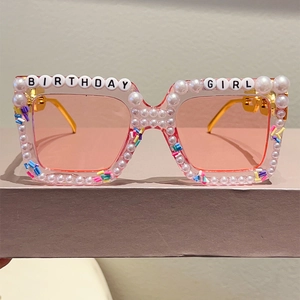 Close-up of Birthday Girl square sunglasses with pink lenses and pearl embellishments