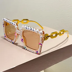 Detail of square birthday girl sunglasses with pearl edges and gold chain temples