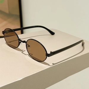 Detailed view of vintage oval sunglasses with sleek black frames and amber lenses