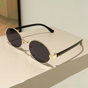 Retro oval metal sunglasses with gold frames and black lenses shown at a 45-degree angle