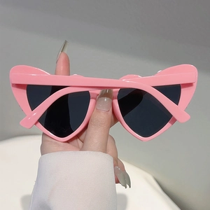 Detail of pink heart-shaped sunglasses with black lenses for bachelorette parties