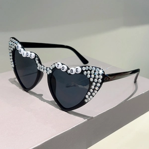 Detail of heart-shaped sunglasses with BRIDE TO BE lettering and sparkling rhinestones