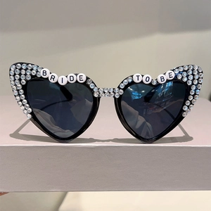 Detailed view of BRIDE TO BE heart-shaped sunglasses with sparkling rhinestone embellishment