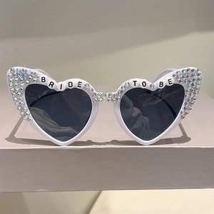 Detail of white heart sunglasses with rhinestones and BRIDE TO BE beaded lettering
