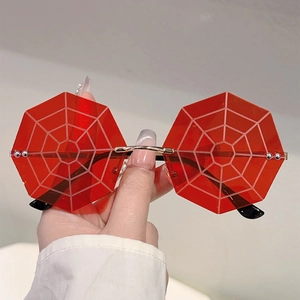 Close-up of red octagonal rimless sunglasses with white spider web lens pattern
