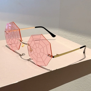 Macro detail of pink octagonal rimless sunglasses with spider web engraving and gold temples
