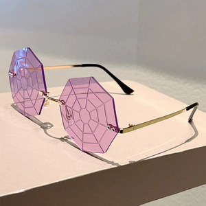 Detail of octagon rimless purple sunglasses with intricate spider web pattern on lenses