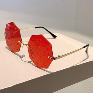 Detail of red octagonal lenses with intricate spider web texture and gold metal arms