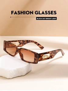 Detailed view of leopard metal hinge on tortoiseshell square frame sunglasses