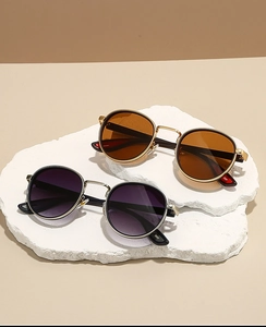 Detailed top view of retro round metal sunglasses on a textured stone display