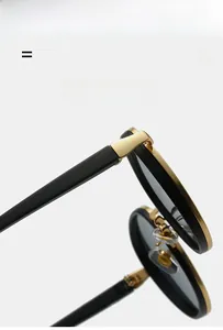 Detail of round sunglasses featuring premium golden metal hinges and black frame