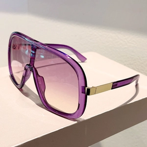 Detailed close-up of purple transparent resin sunglasses with gold metal temple accent