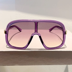 Detail of purple gradient oversized sunglasses with elegant gold temple accents