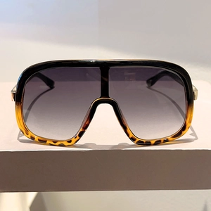 Macro view of leopard print frame sunglasses with gradient lenses and gold metal hinge