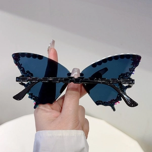 Detail of butterfly shaped party sunglasses featuring blue lenses and colorful bead accents