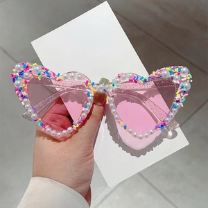 Detail von rosa Herz-Sonnenbrille mit weißen Perlen und bunten Streifenverzierungen