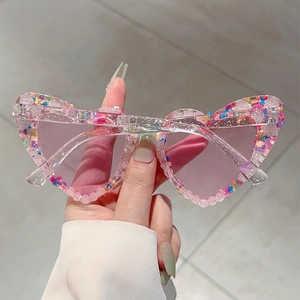 Detail einer herzförmigen rosa Sonnenbrille mit buntem Konfetti-Glitzer im Rahmen