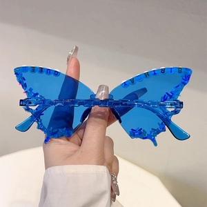 Close-up of blue butterfly party sunglasses with Queen Birthday lettering and pearls