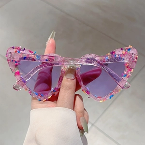 Detail der rosa transparenten Herz-Sonnenbrille mit buntem Glitzer und getönten Gläsern