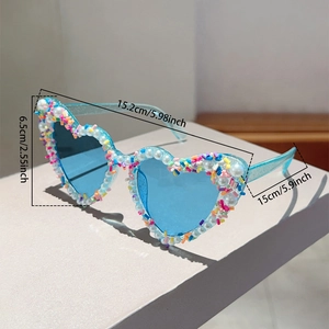 Detailansicht der herzförmigen Sonnenbrille mit blauem Rahmen, Perlen und Streusel-Dekor