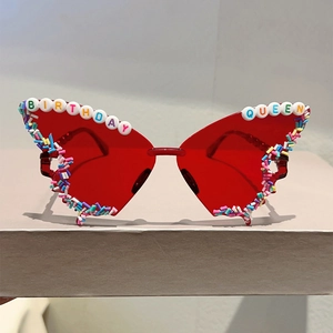 Close-up of butterfly sunglasses with Birthday Queen lettering and candy sprinkles