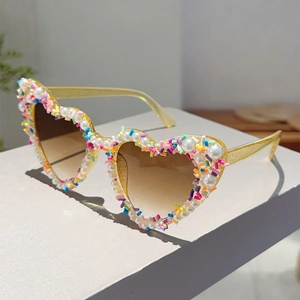 Detail der Herz-Sonnenbrille mit Glitzerrahmen, weißen Perlen und bunten Streuseln