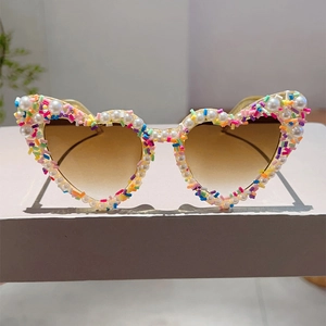 Detail einer herzförmigen Sonnenbrille mit Perlenbesatz und bunten Streusel-Akzenten