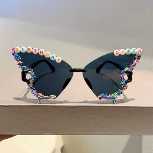 Macro detail of butterfly party sunglasses with Birthday Queen beads and sprinkles