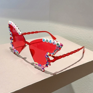 Detail of red butterfly party sunglasses with BIRTHDAY QUEEN bead lettering and pearls