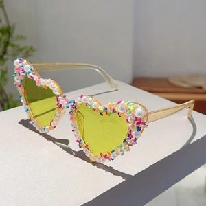 Detail der herzförmigen Partysonnenbrille mit Perleninlay und bunten Akzenten