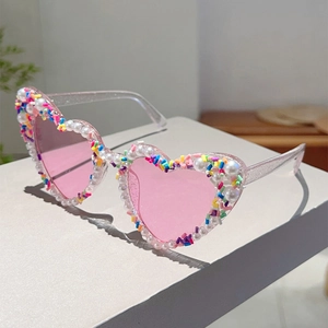Detail der Herz-Sonnenbrille mit Perlenrand und bunten Streuseln auf rosa Gläsern