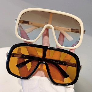 Oversize shield sunglasses with cream and black frames featuring gradient and orange lenses