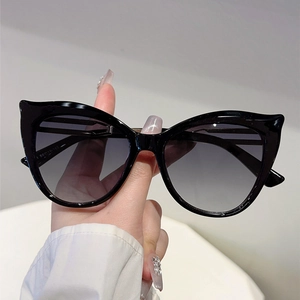 Close-up of black cat-eye sunglasses featuring hollow temples and gradient lenses