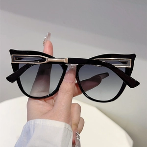 Detail of cat-eye sunglasses with hollow gold metal temples and gradient lenses