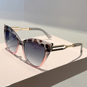 Detail of cat-eye sunglasses with tortoiseshell accents and hollow gold metal temples
