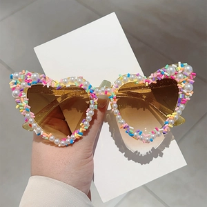 Stylische herzförmige Sonnenbrille mit bunten Perlen und Streuseln für Partys