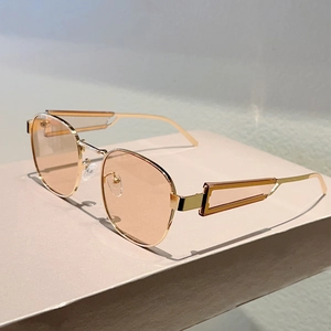 Details goldene ovale Sonnenbrille mit pfirsichfarbenen Gläsern und hohlen Bügeln