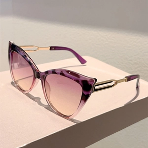 Detail view of cat-eye sunglasses with purple tortoise texture and cutout metal temples