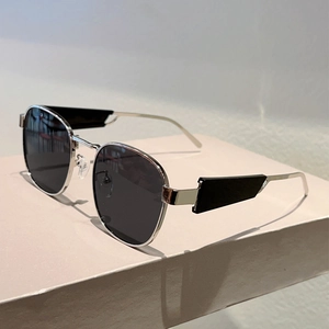 Detailansicht der ovalen silbernen Metall-Sonnenbrille mit dunklen Gläsern und Dekor-Bügeln