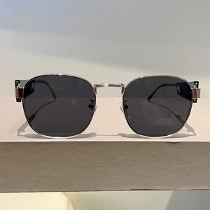 Details einer silbernen ovalen Sonnenbrille mit geometrischem Stufendesign am Bügelgelenk