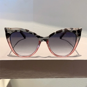 Detail of cat-eye sunglasses with leopard print frame and gradient grey lenses