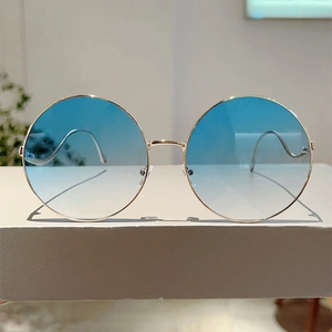 Detailed view of round gold metal frame sunglasses with light blue gradient lenses