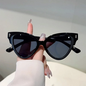 Detail of black cat-eye sunglasses featuring silver metal accents on the frame temples