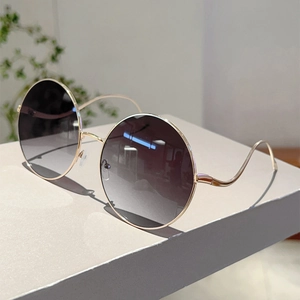 Classic round metal sunglasses with gold frames and dark grey gradient lenses for women