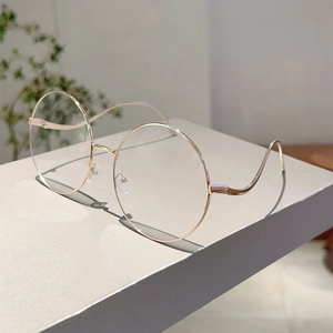 Detail of round gold metal sunglasses with stylish wave-shaped temples and clear lenses