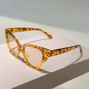 Close-up of tortoise shell cat-eye glasses frame on a minimalist geometric stand
