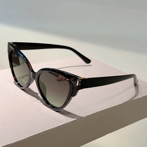 Detail of cat eye sunglasses with tortoiseshell frame and silver metal hinge decoration