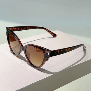 Detail of cat-eye sunglasses with tortoiseshell frame and gradient brown lenses