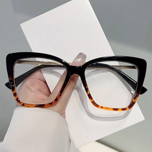 Dettaglio montatura cat-eye con parte superiore nera, maculato e aste in metallo dorato