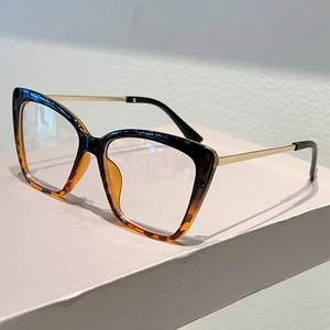 Dettaglio occhiali cat-eye con montatura sfumata tartarugata e stanghette in metallo oro